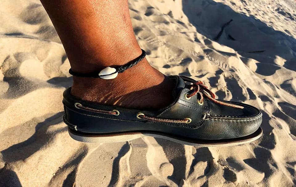 Fußkettchen aus Leder mit Kauri-Muschel – maritimes Accessoire für Damen und Herren am Strand.